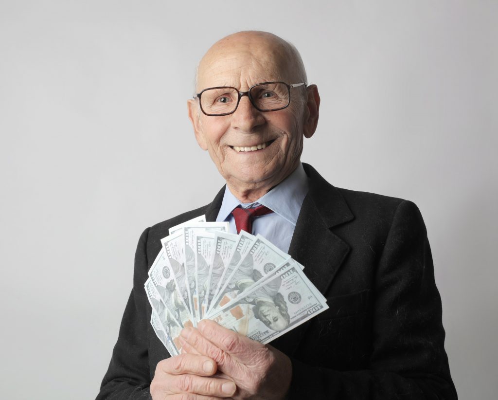 happy older man with money fanned out